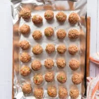 scooped up meatballs shaped into perfect meatball shape on a sheet pan