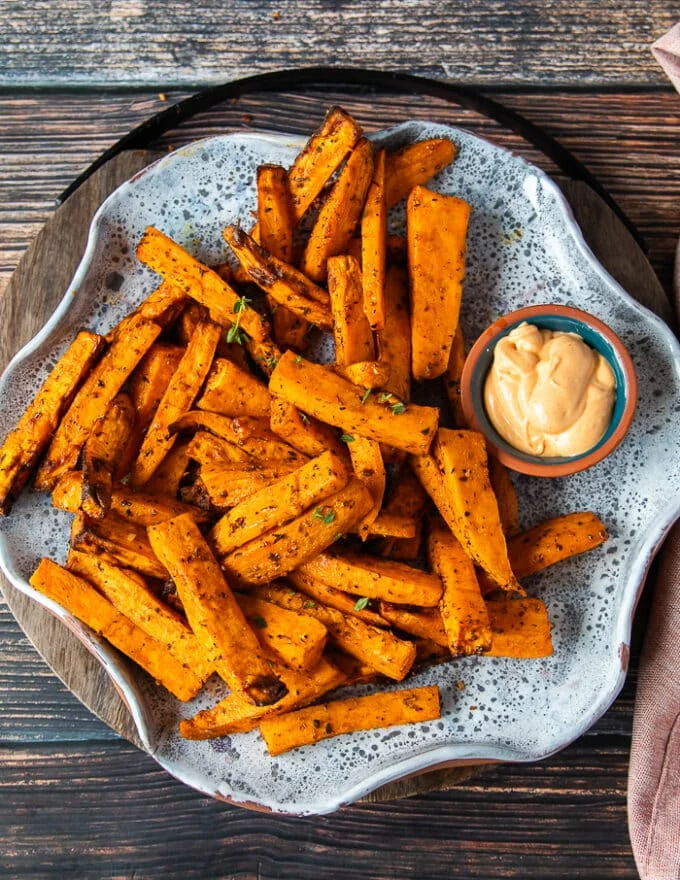A plate with air fryer sweet potato fries and a dip on the side