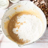 dry ingredients are added to the wet ingredients in a large bowl to make banana bread muffins