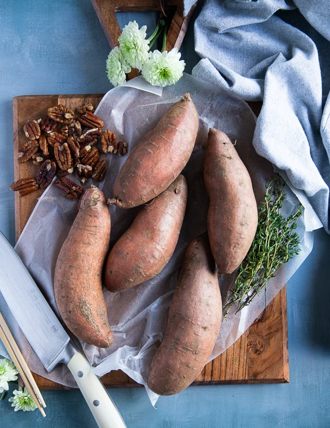 washed sweet potatoes on a cutting board ready to cut