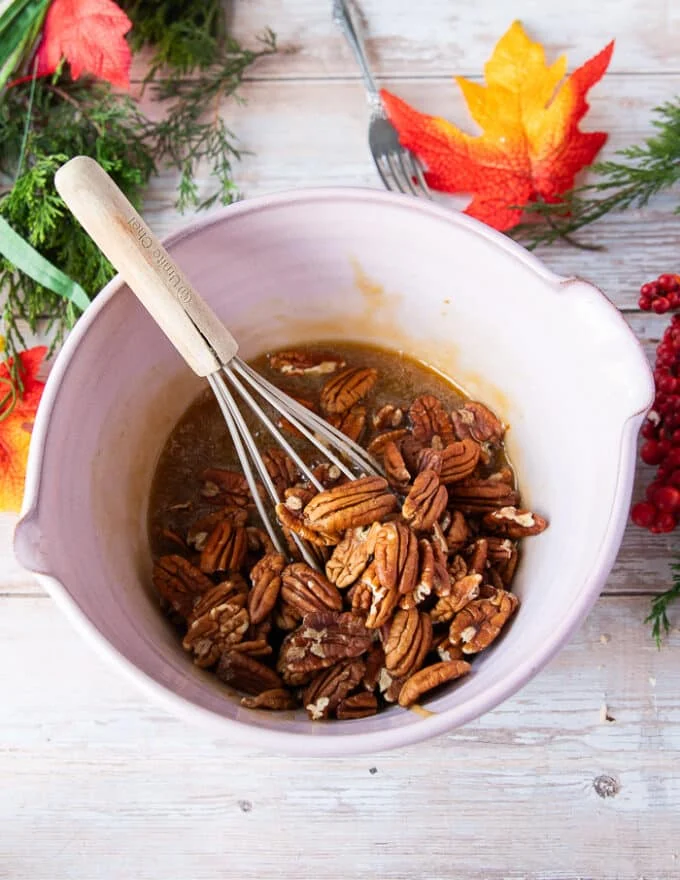 Pecans added into the bowl after the caramel sauce is complete