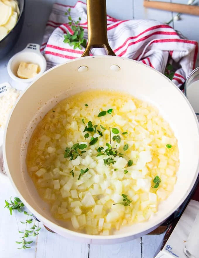 Butter melted in a skillet with diced onions and herbs