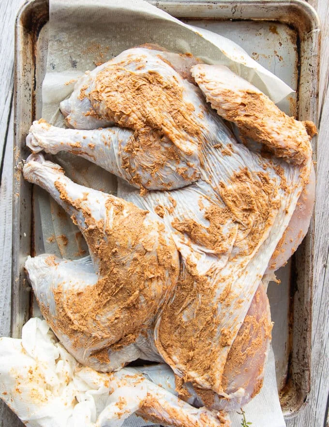 the spatchcock turkey slathered in the herb butter on the top and in between the skin evenly