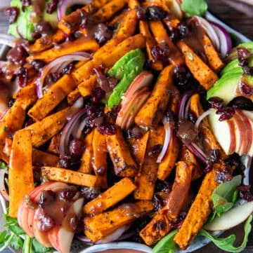 Sweet potato salad all dressed up on a plate with avocados, cooked wild rice, sweet potatoes, apples,onions and cranberries