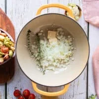 The diced onions and thyme are added to a pot to sautee with butter