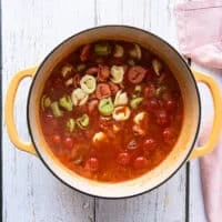 The tortellini is added to the pot of simmering tomato broth to cook