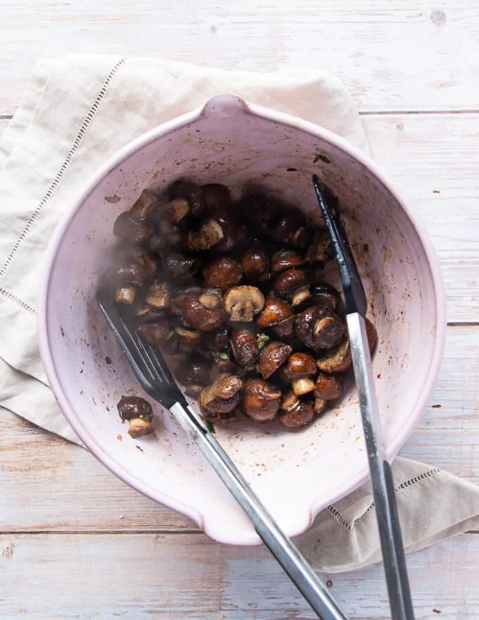 The mushrooms tossed in the melted butter, garlic and parmesan mixture in a bowl