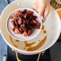 The crumbled bacon or sausage is removed on to a plate