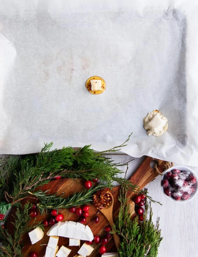 A chunk of cut up brie cheese is placed over the hot honey