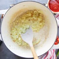 The onion is cooking in oil in a large soup pot to make taco soup