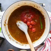 The canned cherry tomatoes in their juices are added in the taco soup pot along with the stock and one jalapeno