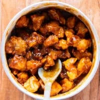 the fried chicken added to the pot of orange sauce and tossed well to coat