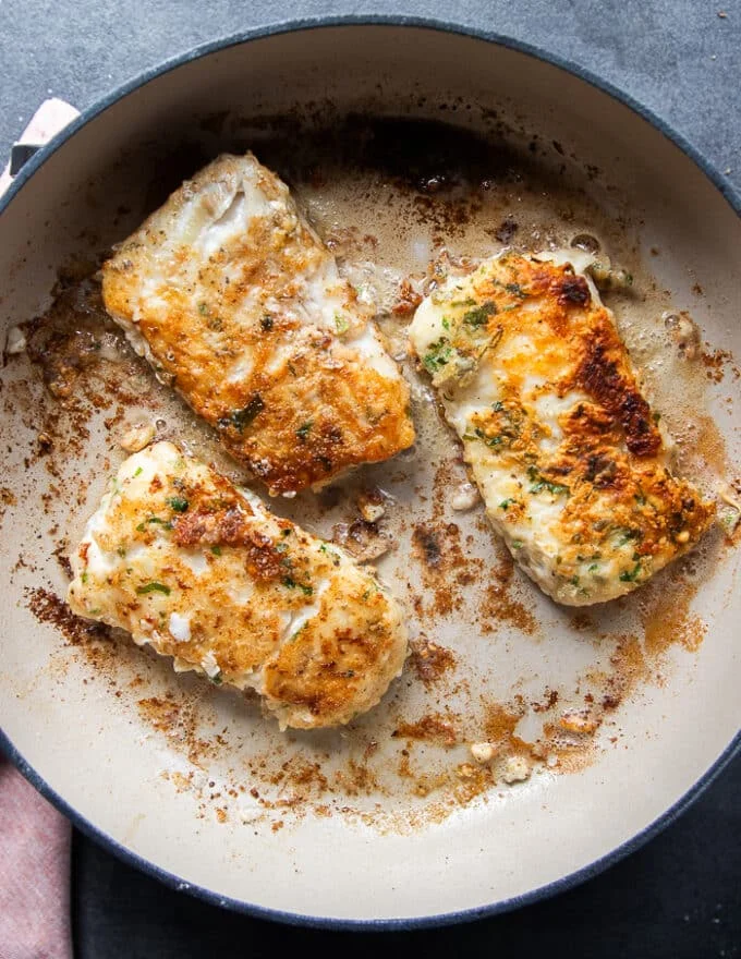 Golden cod fish pan seared and flipped to cook on the other side.