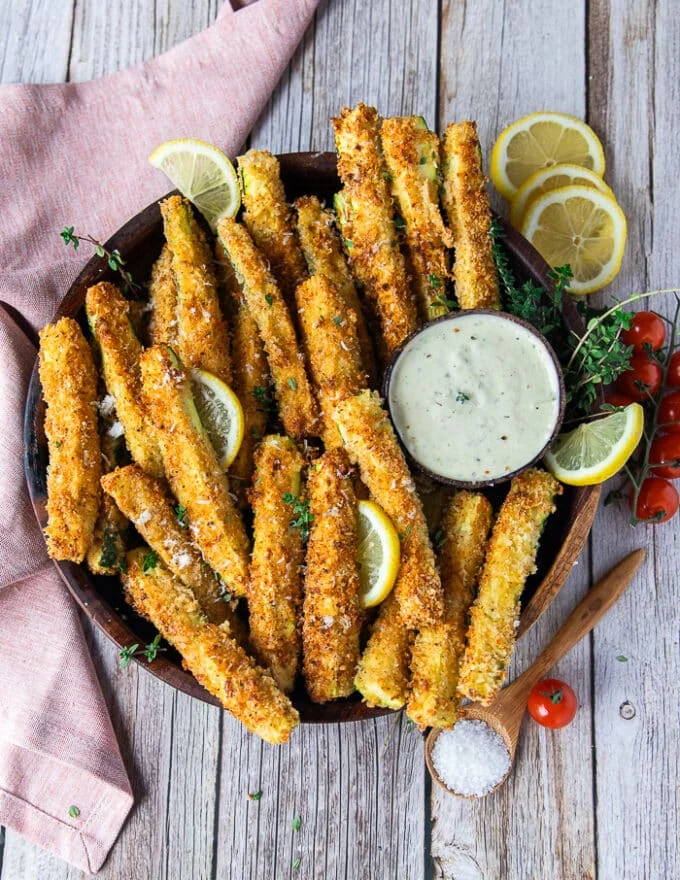The final plate of zucchini fries served with dipping sauce, lemon slices and ready to eat