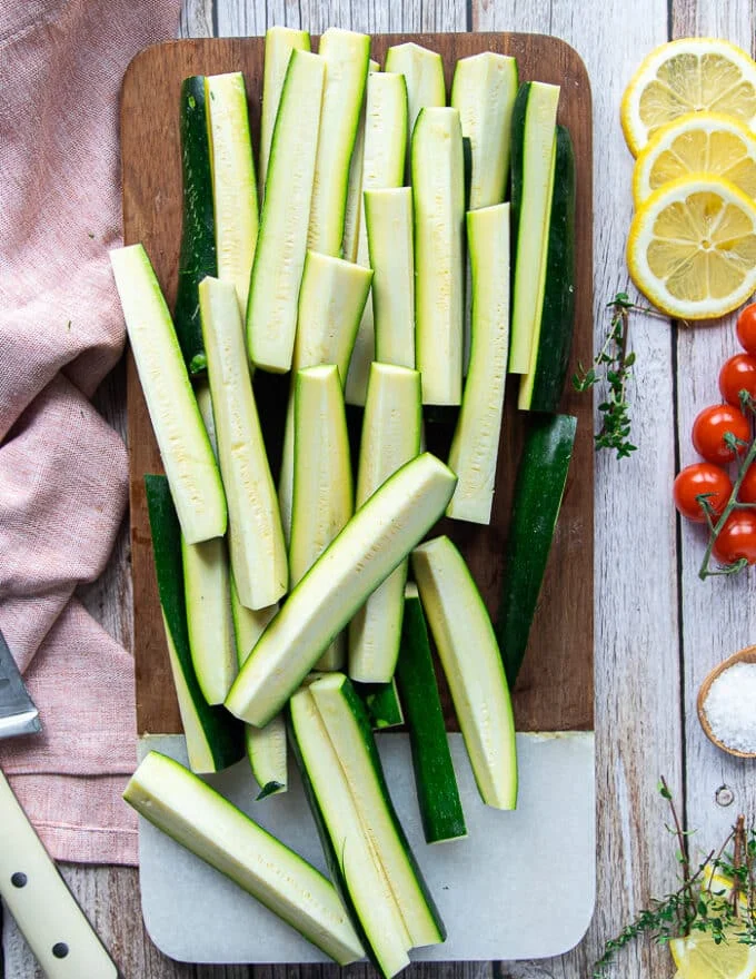 Zucchini cut into fries shape on a wooden board