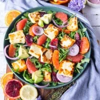 Halloumi cheese, toasted almonds, some onions and avocados layered over the salad plate