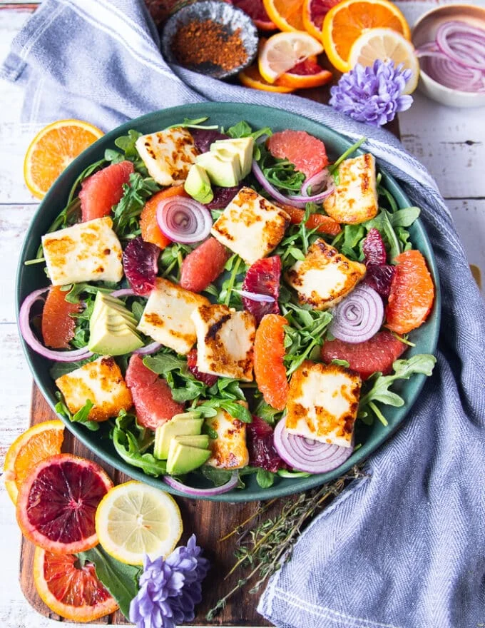 Halloumi cheese, toasted almonds, some onions and avocados layered over the salad plate