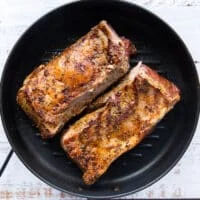 Golden seared lamb loins flipped and cooked on the other side