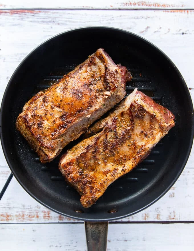 Golden seared lamb loins flipped and cooked on the other side