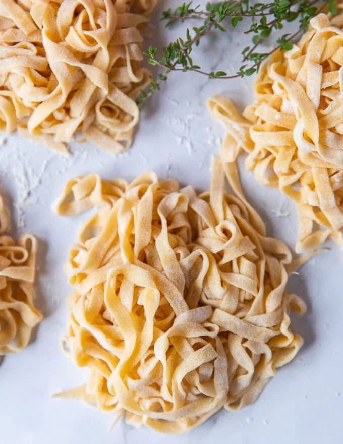 mounds of fresh pasta on a plate ready to use for our lobster pasta recipe.