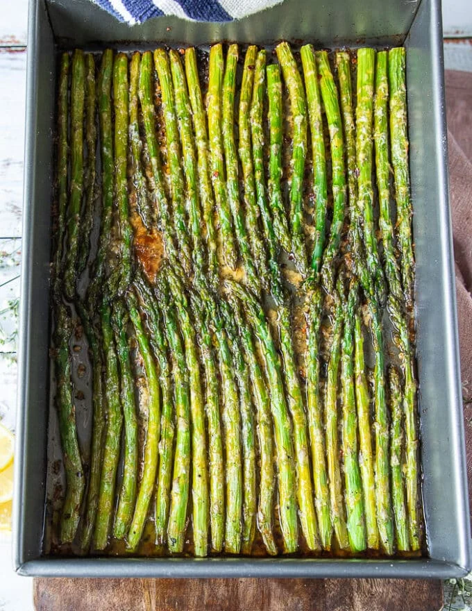 Asparagus perfectly roasted with a delicate golden crisp from the parmesan cheese ready out of the oven and still on the pan