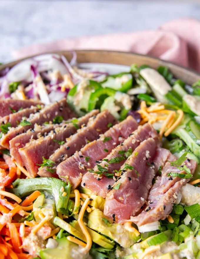 close up of the sliced ahi tuna over the salad with sesame dressing