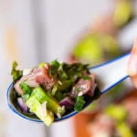 close up of a spoonful of tuna ceviche served as an appetizer with seaweed