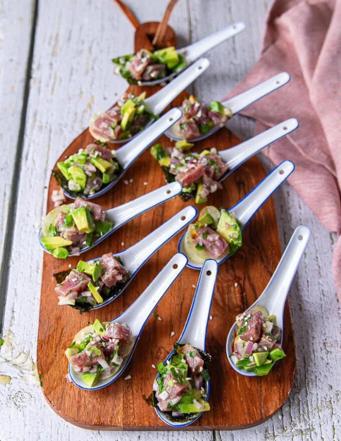 A full board with spoonful appetizers of tuna ceviche