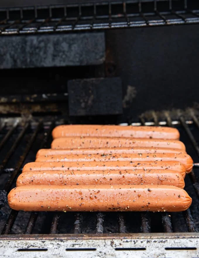 The hot dogs are placed on a medium hot grill