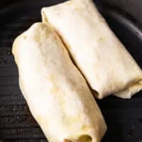 two tuna wraps folded and placed in a grill pan to press down