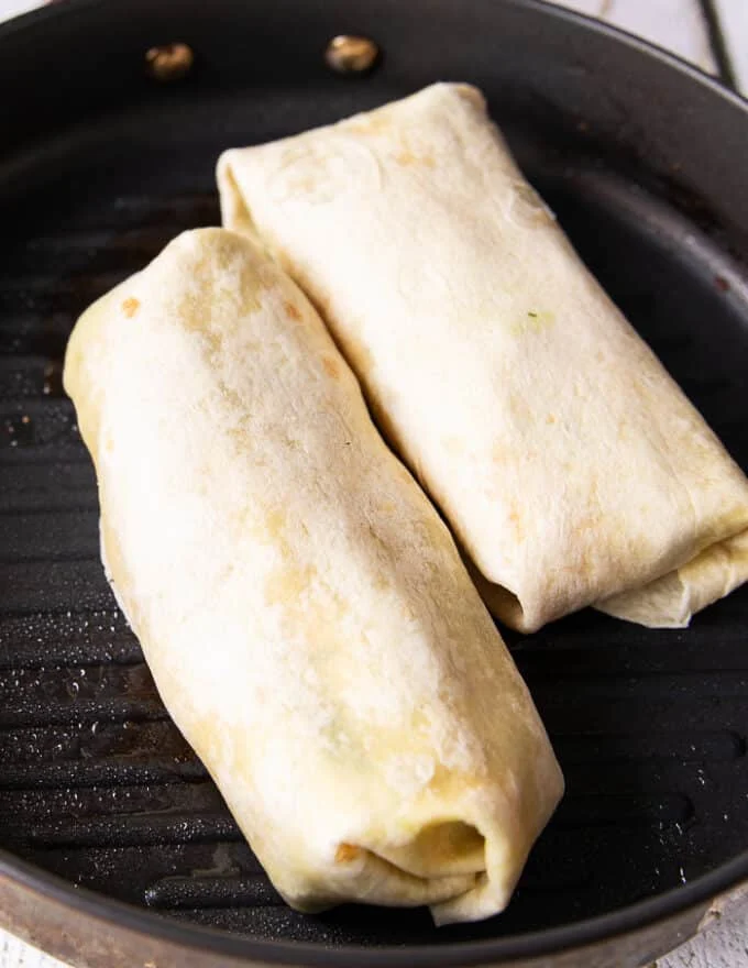 two tuna wraps folded and placed in a grill pan to press down