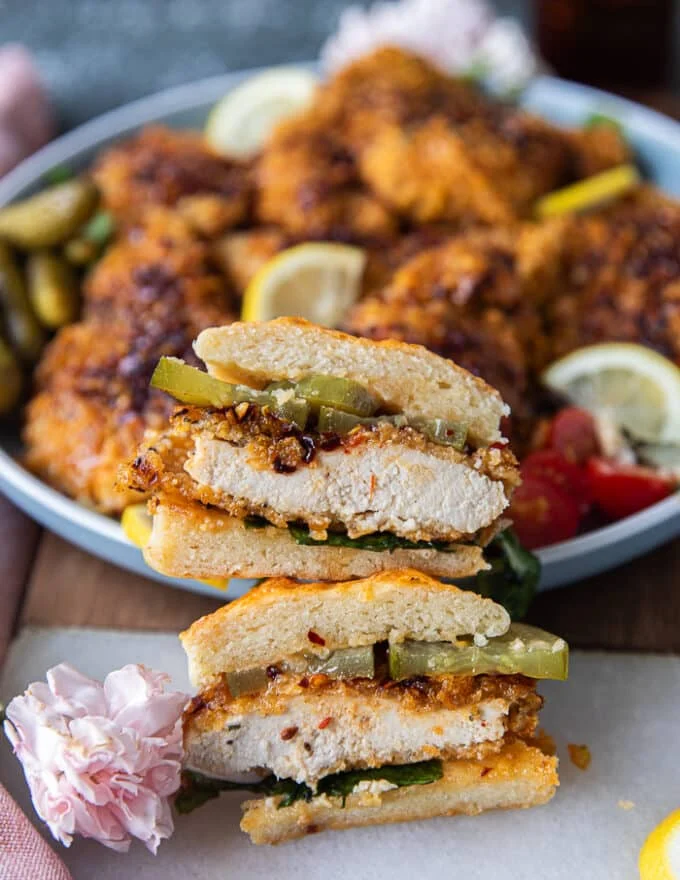 Hot honey chicken sandwich cut in half showing the inside of the chicken and the layers of the sandwich
