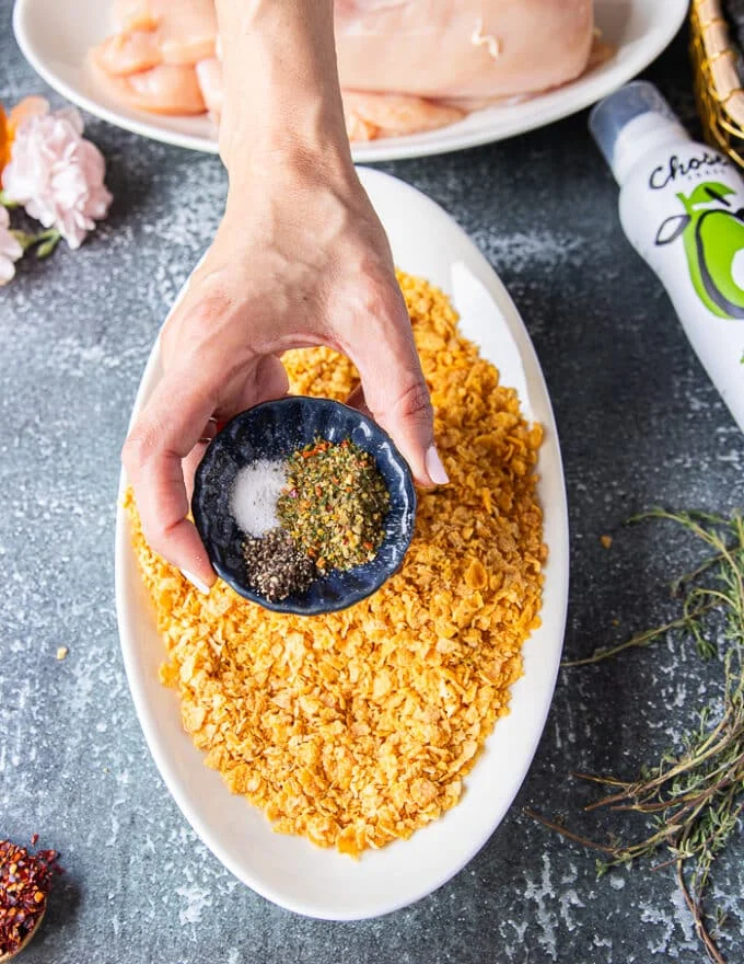 The cornflakes plate being seasoned withe the spice blend in a shallow plate to prepare the coating