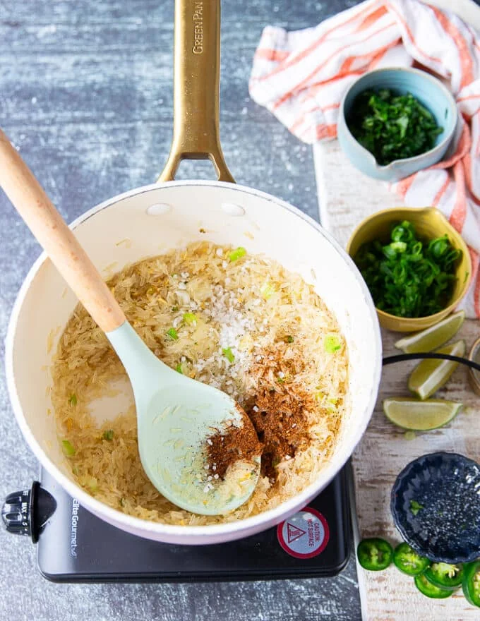 The rice is seasoned with salt and chilli powder in the pot