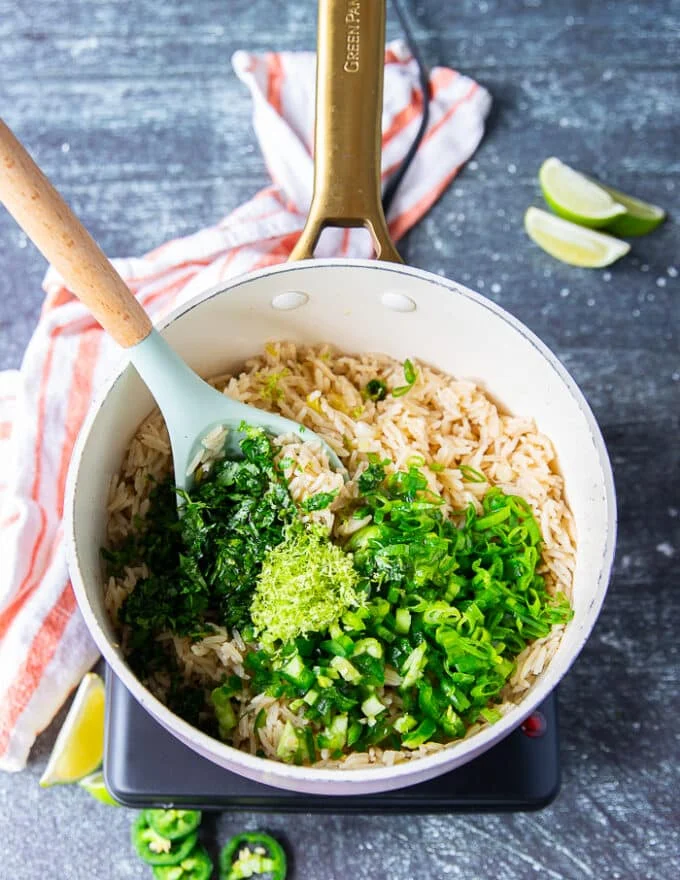 right over the cooked rice there's fresh cilantro, minced jalapeno, minced scallions, lime zest and lime juice and some olive oil added in the pot