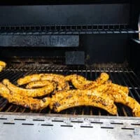 corn ribs cooking on the grill grates and charred