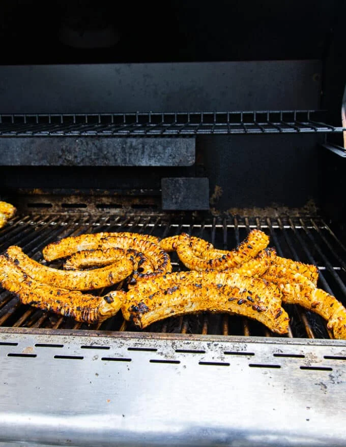 corn ribs cooking on the grill grates and charred