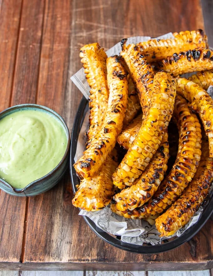 perfectly golden and crisp corn ribs in a basket ready to serve