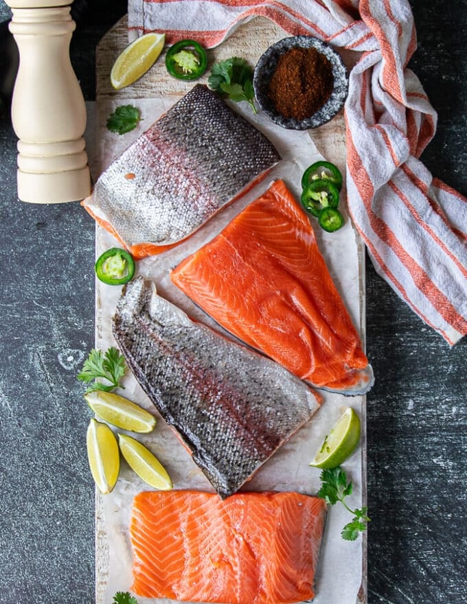 A board with rainbow trout surrounded by salt, pepper and chilli powder, and some oil