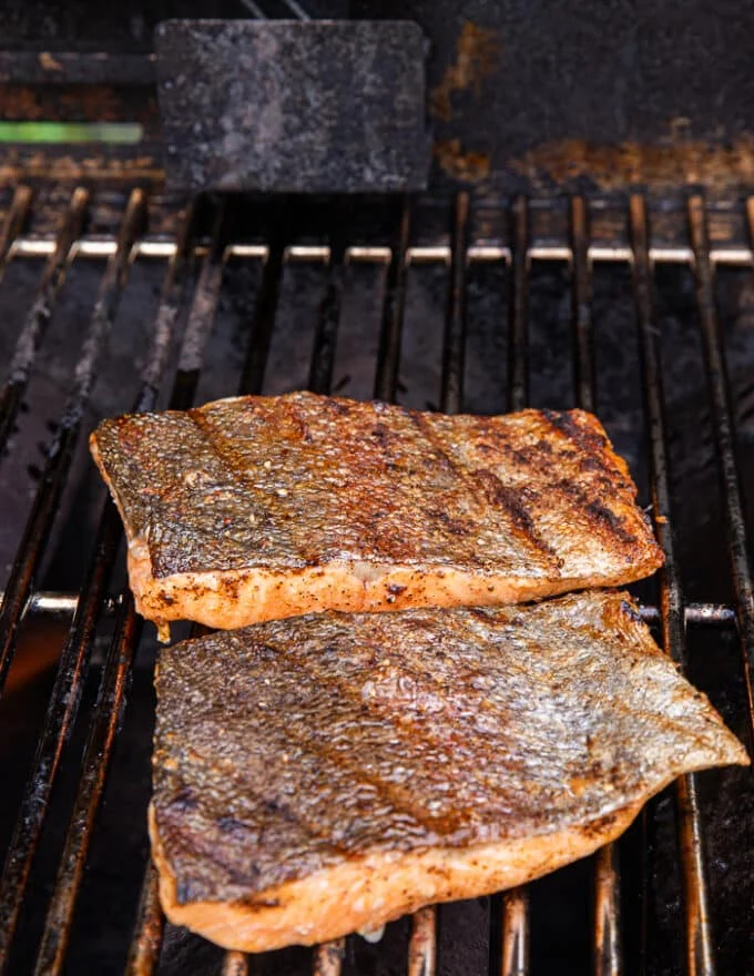 Crispy trout skin grilled and flipped showing the grill marks