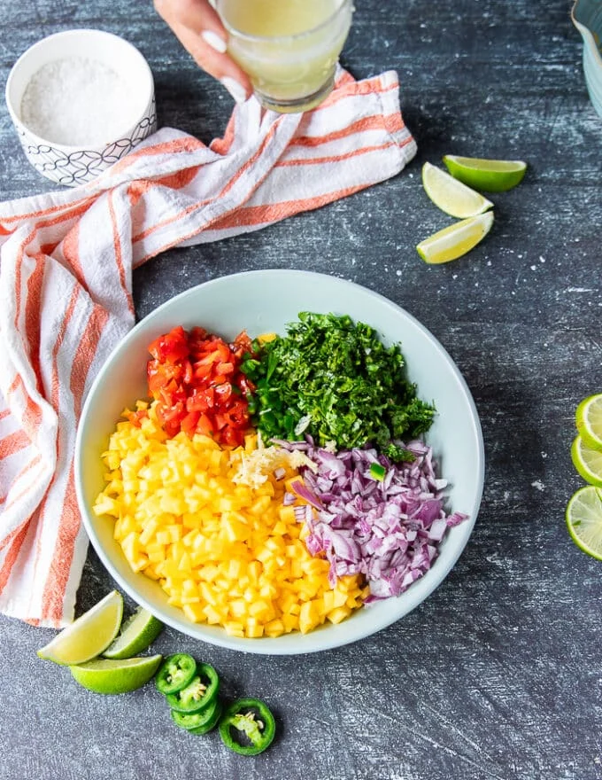 All ingredients of the mango pico de gallo added into a large shallow bowl together