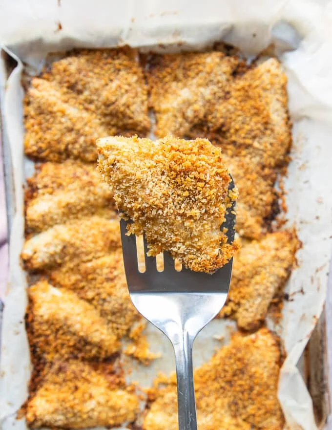 A spatula showing close up on the perch right out of the oven, golden in color and crisp outer coating, and fully cooked fish