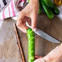 A hand showing how the cucumbers are ready cut up and spiralled