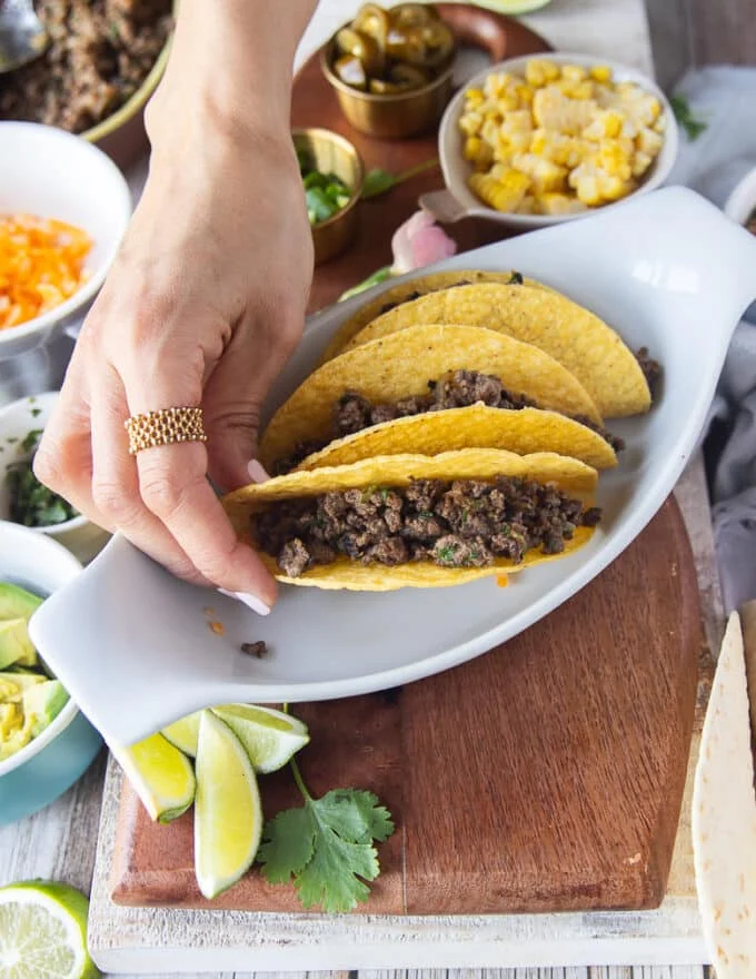 the ground beef is now added over the cheese in the taco shell