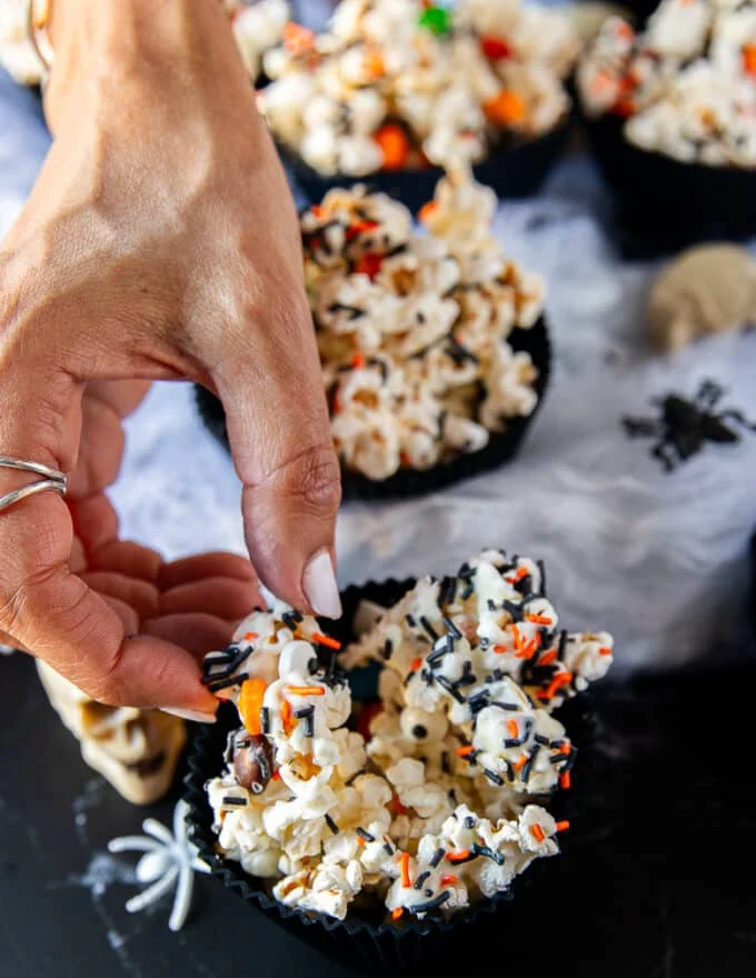 A hand grabbing the halloween popcorn showing close up of the texture