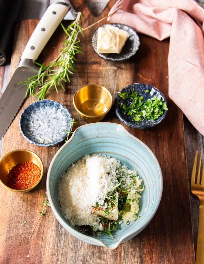 garlic butter ingredients all added into the bowl including the soft butter, fresh garlic, herbs and seasoning
