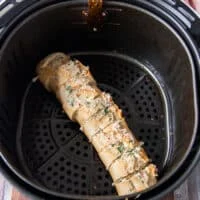 The garlic bread all slathered in butter and placed in the air fryer basket