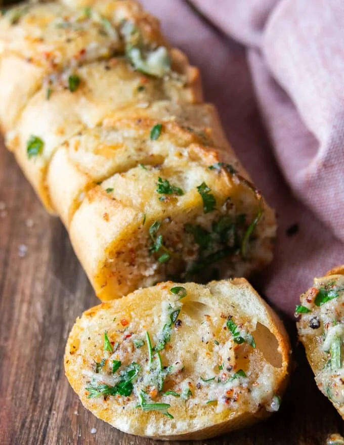 close up of one piece of air fryer garlic bread showing the crisp outside and the garlicky butter herb inside