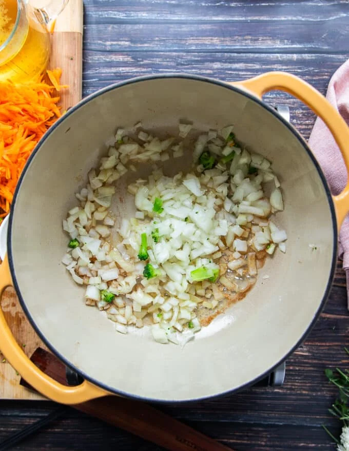 A large pot with the onions sautéing in butter