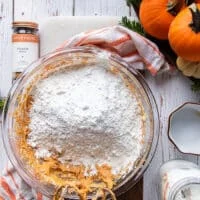 The flour, baking soda and baking powder are added on to the pumpkin bread batter now and a spatula is used to incorporate them